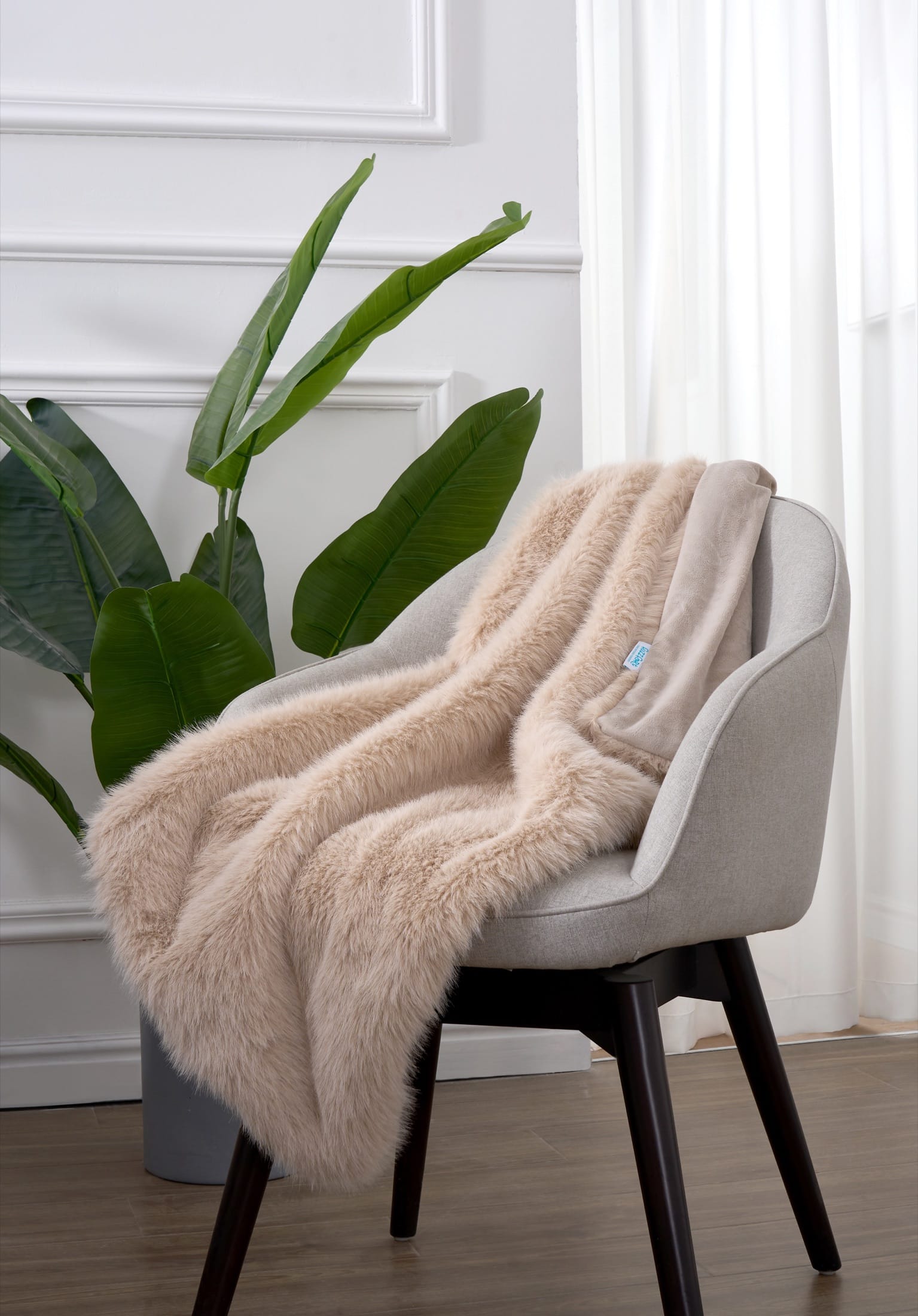 Plush throw blanket draped over a chair in a bright room